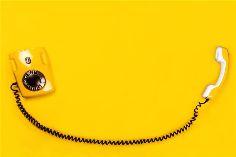 telefone fixo em fundo amarelo